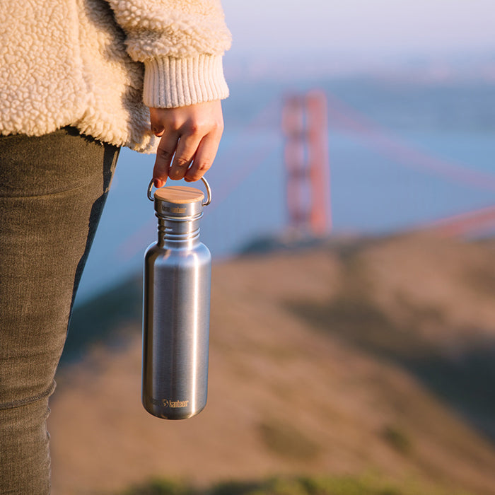 27oz-reflect-with-bamboo-cap-f1 K27SSLRF-BS-BAMBOO_reflect_bottle_bridge_lifestyle.jpg